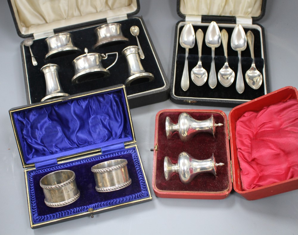 Four cased sets of silver, including pair of napkin rings, six grapefruit spoons, condiment set and pair of pepperettes.